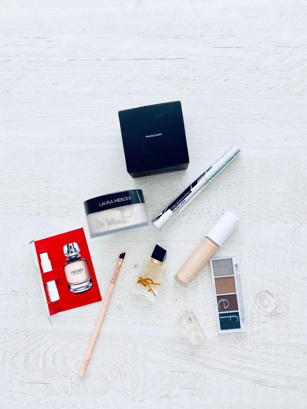 A stylish collection of luxury makeup items on a white background