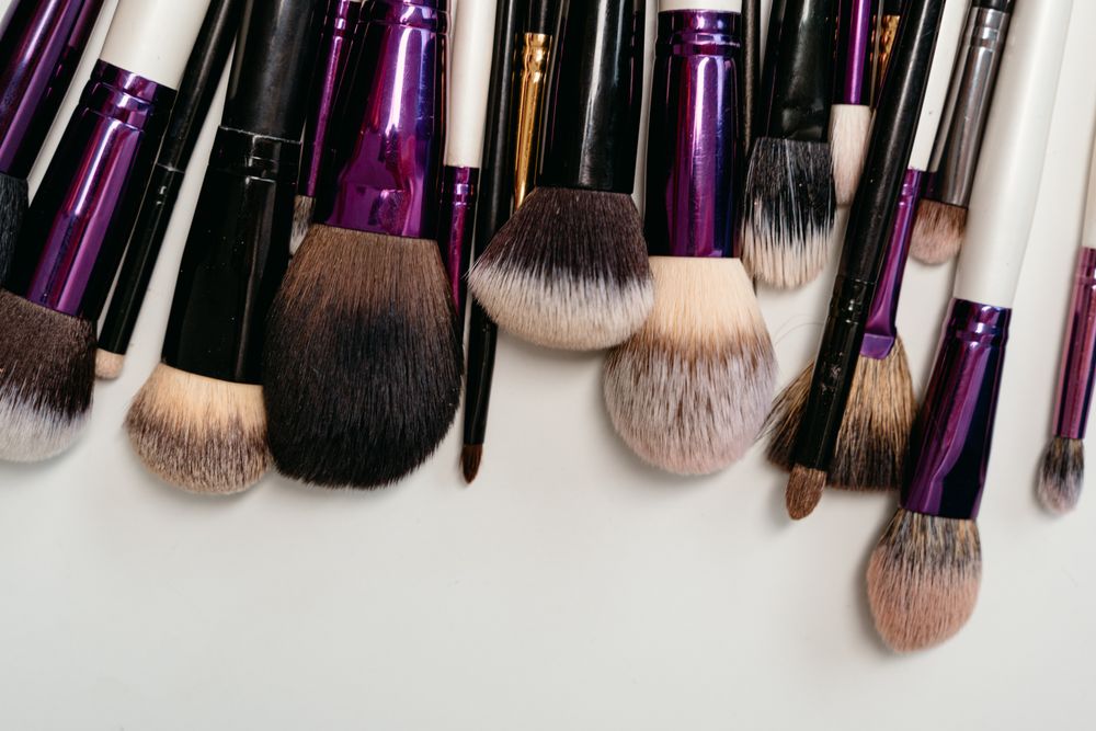 A flat lay of makeup brushes with soft bristles on a white background