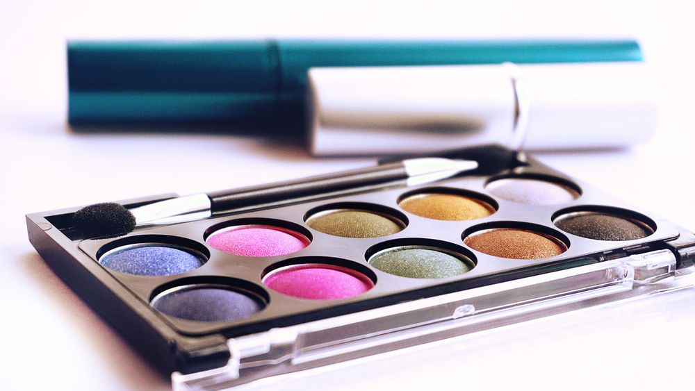 A colorful eyeshadow palette with a brush