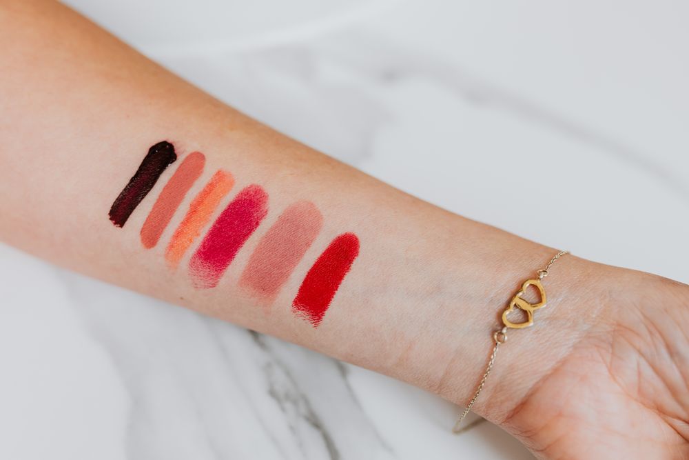 Lipstick swatches in rose tones applied on a forearm