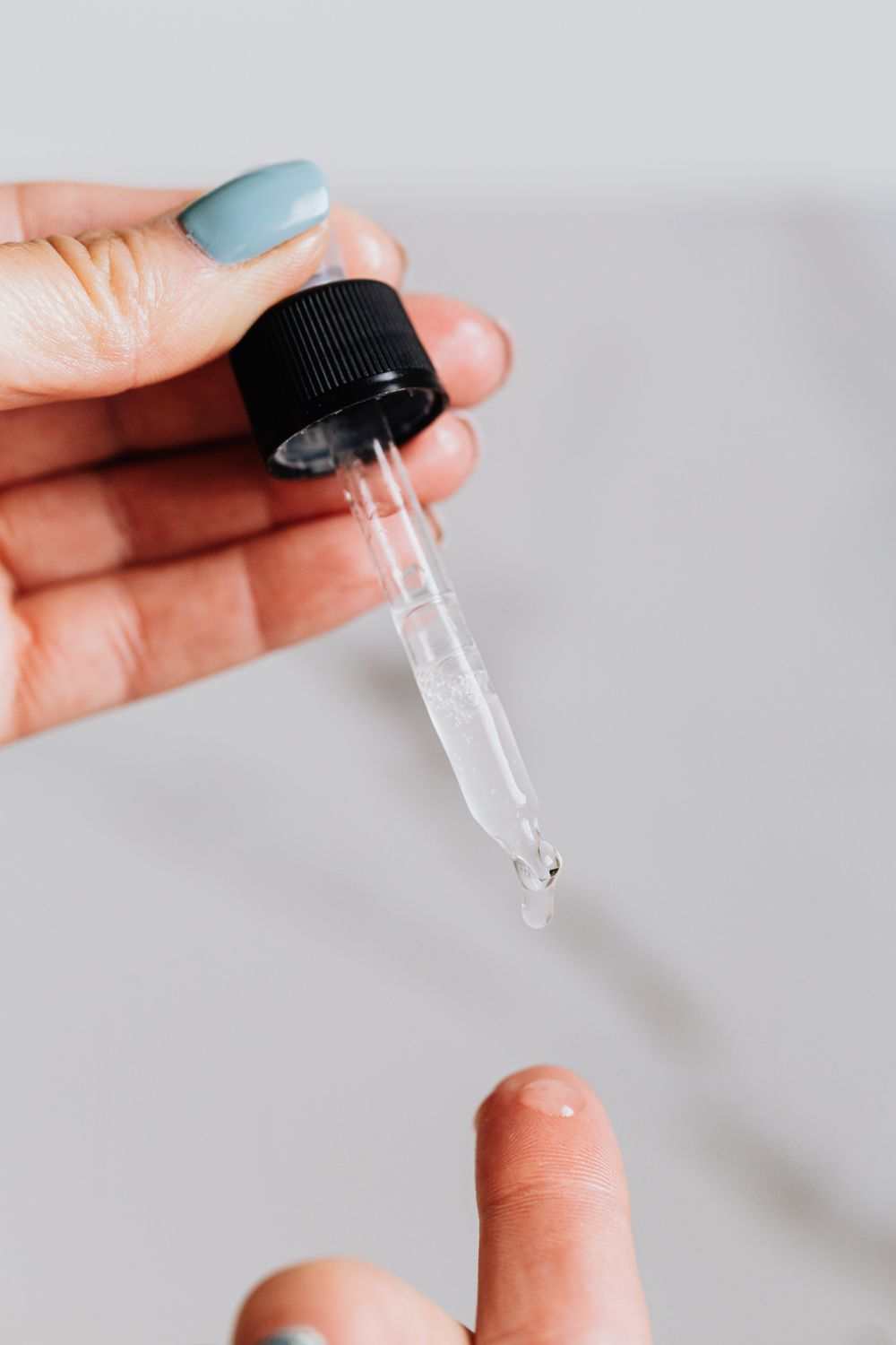 A dropper releasing skincare serum liquid
